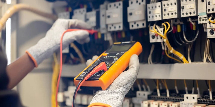 Electrician carrying out fixed wire testing on a commercial panel