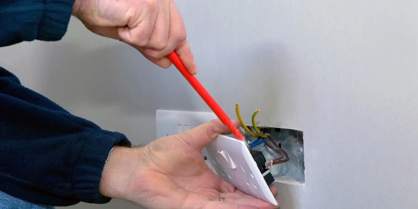 Electrician installing a commercial power socket